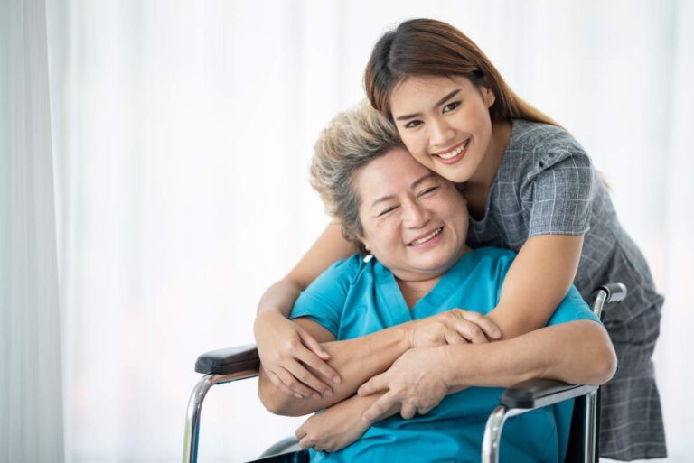 A caregiver assisting an elderly person with walking inside a cheerful, sunlit living room.